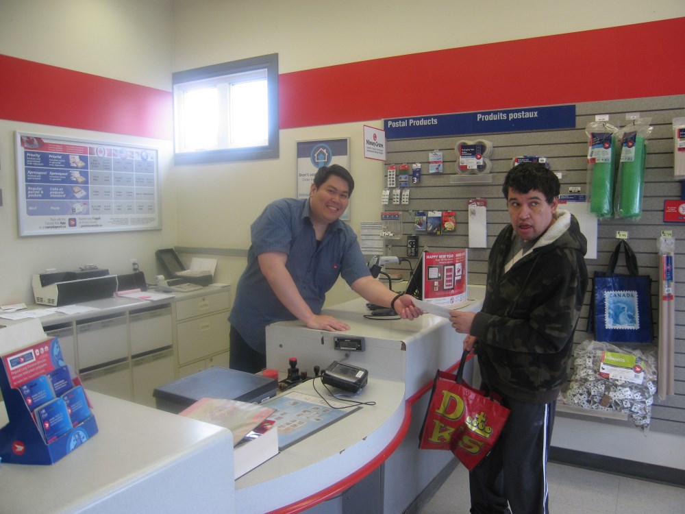 A customer interacts with a clerk at a service counter in a retail environment, with various items displayed on the shelves in the background.